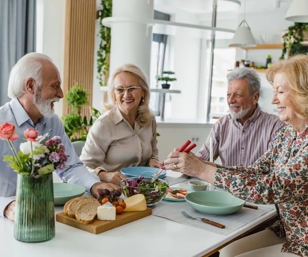 Seniors laughing together over a meal