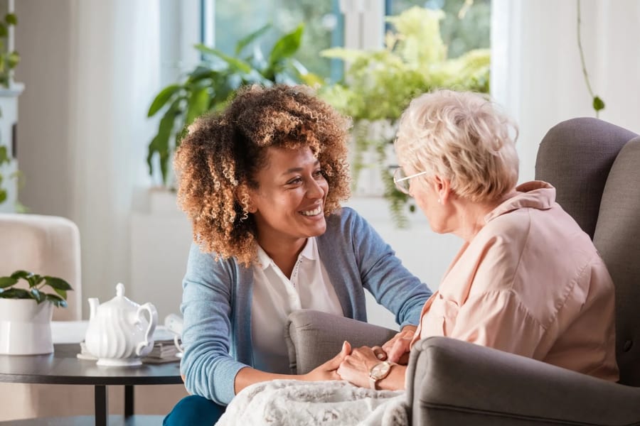 Caregiver having a warm conversation with an elderly woman